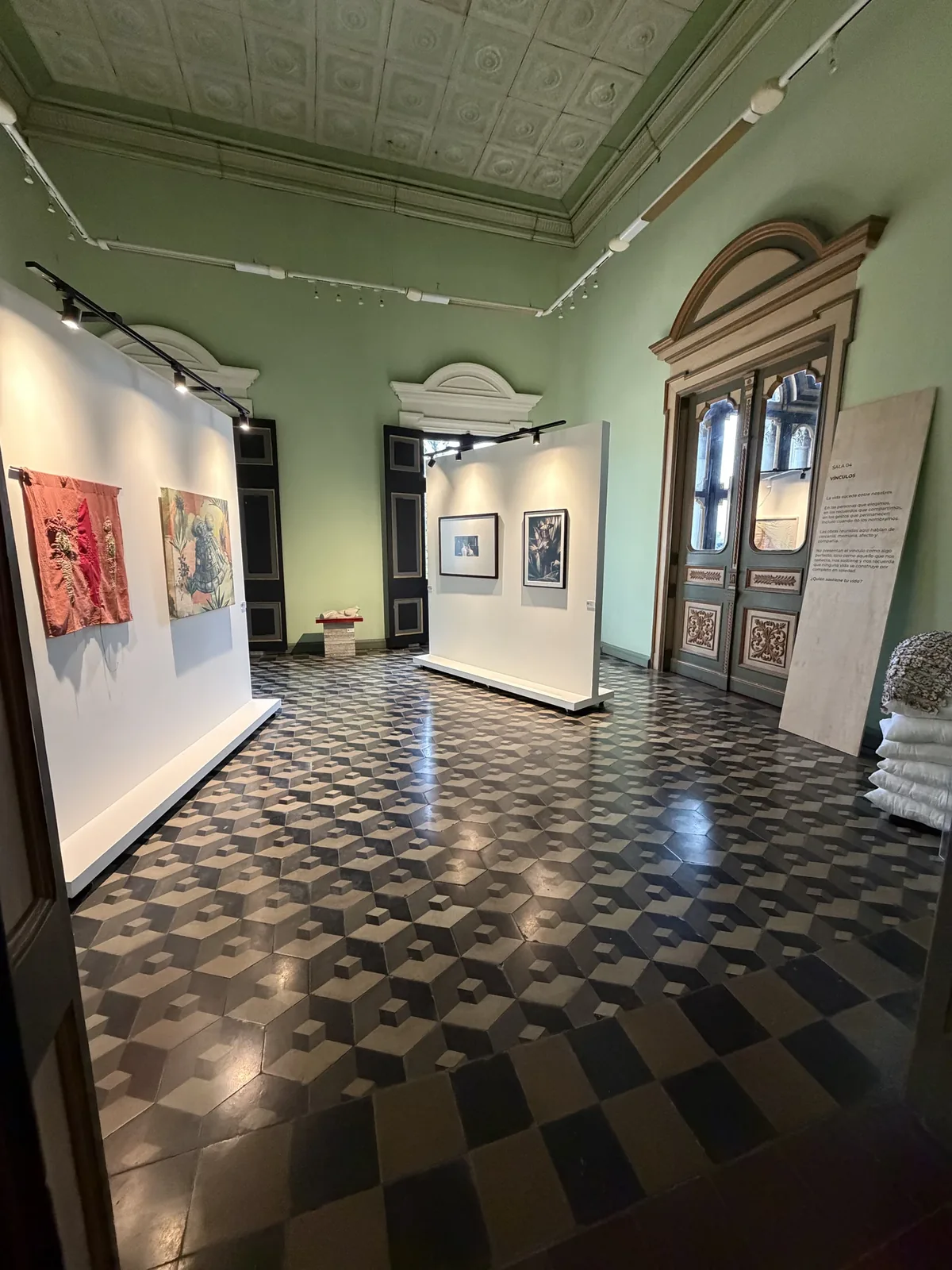 Montaje de la Sala 04 — Vínculos: vista general del salón con piso de cubos y muros expositivos